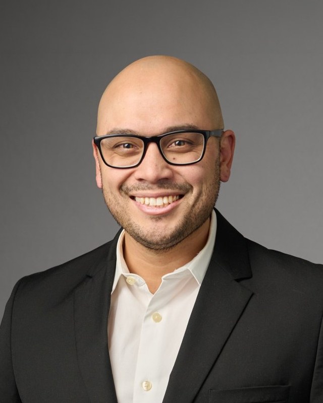 Portrait of Jared Dumale in a dark blazer and white shirt